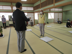 皆勤賞の表彰状を読み上げる館長と表彰される男性