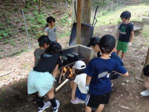 火加減を見ながら飯盒でご飯を炊く子供たちの様子