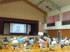 気仙沼市からオンライン中継で講演される講師が映し出されたスクリーンの写真