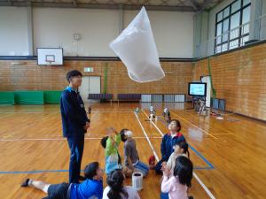 浮き上がった袋を見上げる子供たち