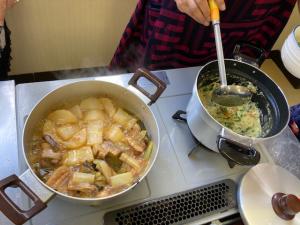 鍋で煮込まれているオレンジ煮と粉どうふの野菜煮の写真