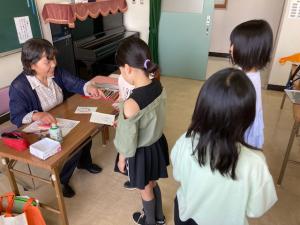 先生に色の塗り方を教えてもらう子供の様子の写真