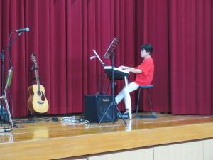 舞台の上でエレクトーンを演奏している演者