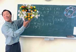 寄せ植えリースを手に説明する講師の写真