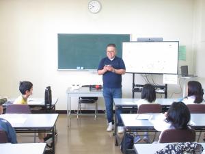 ドローンの仕組みを説明する講師と熱心に聞いている子供たちの様子