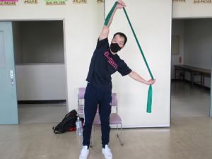 講師がゴムチューブを使った体操している写真