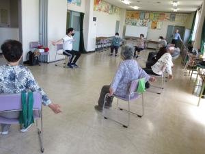 椅子に座って体操をしている様子の写真