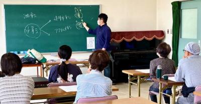 黒板を使って水彩画の説明をする講師の写真