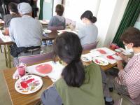 リンゴの絵に色つけをしている写真