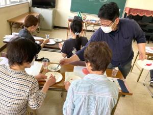 生徒の作品にアドバイスしている先生の写真