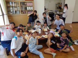緑班：完成したピザを前にみんなでポーズをする子供たち