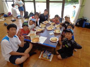 青班：出来上がったピザの前でポーズをする子供たち