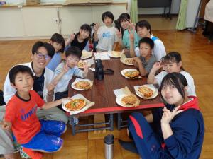 赤班：出来上がったピザのまえでポーズをする子供たち