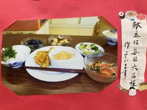 白飯におかず5品とデザート1品の写真