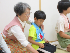 講師から座り方の指導を受ける子供の写真
