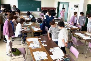 ほかの人の作品をみんなで順番に見回っている写真