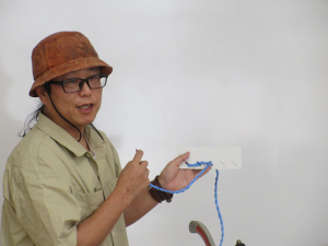 見本の川と糸を使って縫い方を説明する講師