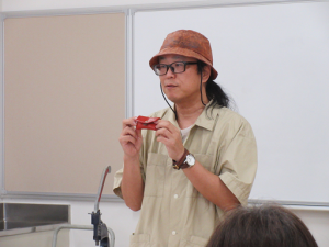 小銭入れを手に持ち説明する講師