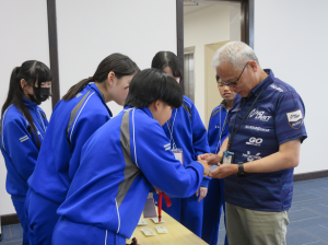 受付担当の中学生たちと受講者の写真