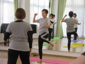 両手を構え、けりをする見本を見せる講師