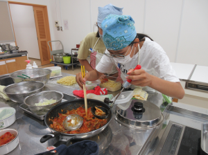 慎重にフライパンの料理をお玉に取っている写真