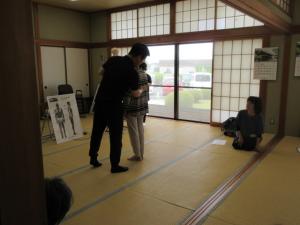 痛みの症状のある受講生に先生が施術をしている様子