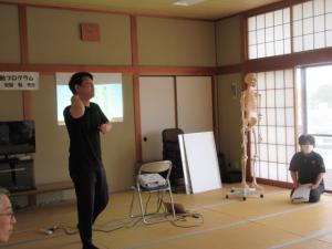 先生が体の部位や痛みの起こる原因を説明している様子