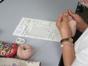 編図を見ながらスマホポシェットを編んでいる受講生の様子
