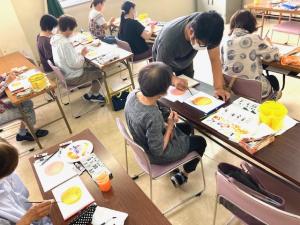 受講生の絵にアドバイスをしている講師の写真
