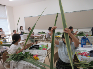 花材を両手に持ち、アレンジする考える子どもたち