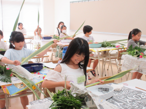 笑顔で花材を生ける子どもたち