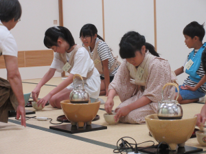 上達した手つきでお茶をたてる子ども達