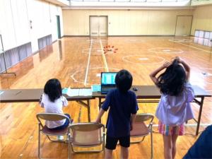 ドローンがミッションをクリアするか見守る子供たちの様子