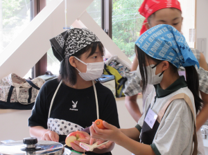 りんごと人参の皮をむく子ども達