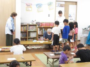 先生の前に列を作って待っている子供たちの様子