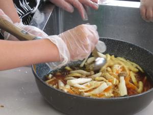 フライパンで炊き込みご飯を作るために、調味料を入れている様子