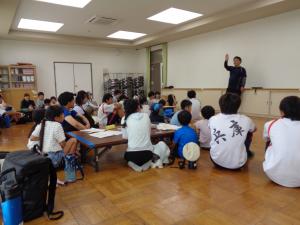始まりの会でスタッフの話を聞く参加者