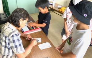 先生に色の重ね方を教わる子供の様子