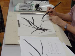 葉っぱのしなやかさを墨で表現する受講生の写真