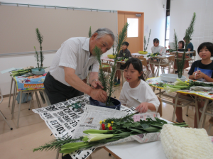 ２本のまきの木を剣山に生ける講師
