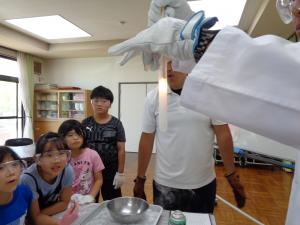 液体酸素になった酸素に線香を近づけると勢い良く燃える実験