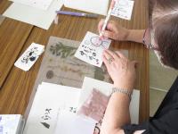 ハガキに色付けをする受講生の様子