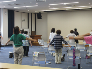 両手を広げて体操する受講生。少々間違って大丈夫