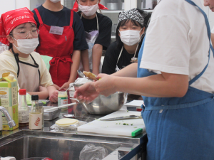 餃子の包み方の説明に耳を傾ける子ども達