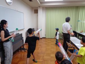 カーテンに向けてビニールロケットを飛ばす男の子