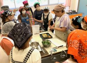 受講生を集めて料理の手順を説明している講師の写真