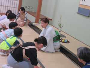 子どもたちに季節の花を説明される講師先生