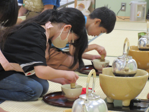 茶せんを使ってお茶を立てる子ども達