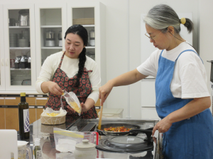 料理の見本づくりを進める講師のお二人