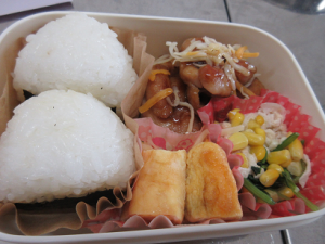 おにぎり、卵焼き、野菜を盛りつけたお弁当